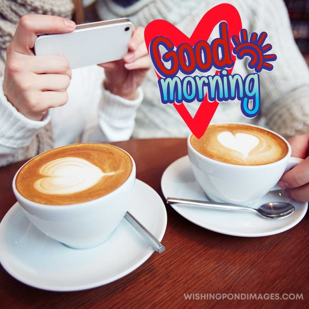 Couple sitting in a cafe drinking coffee and taking picture with phone. Good Morning Coffee Images